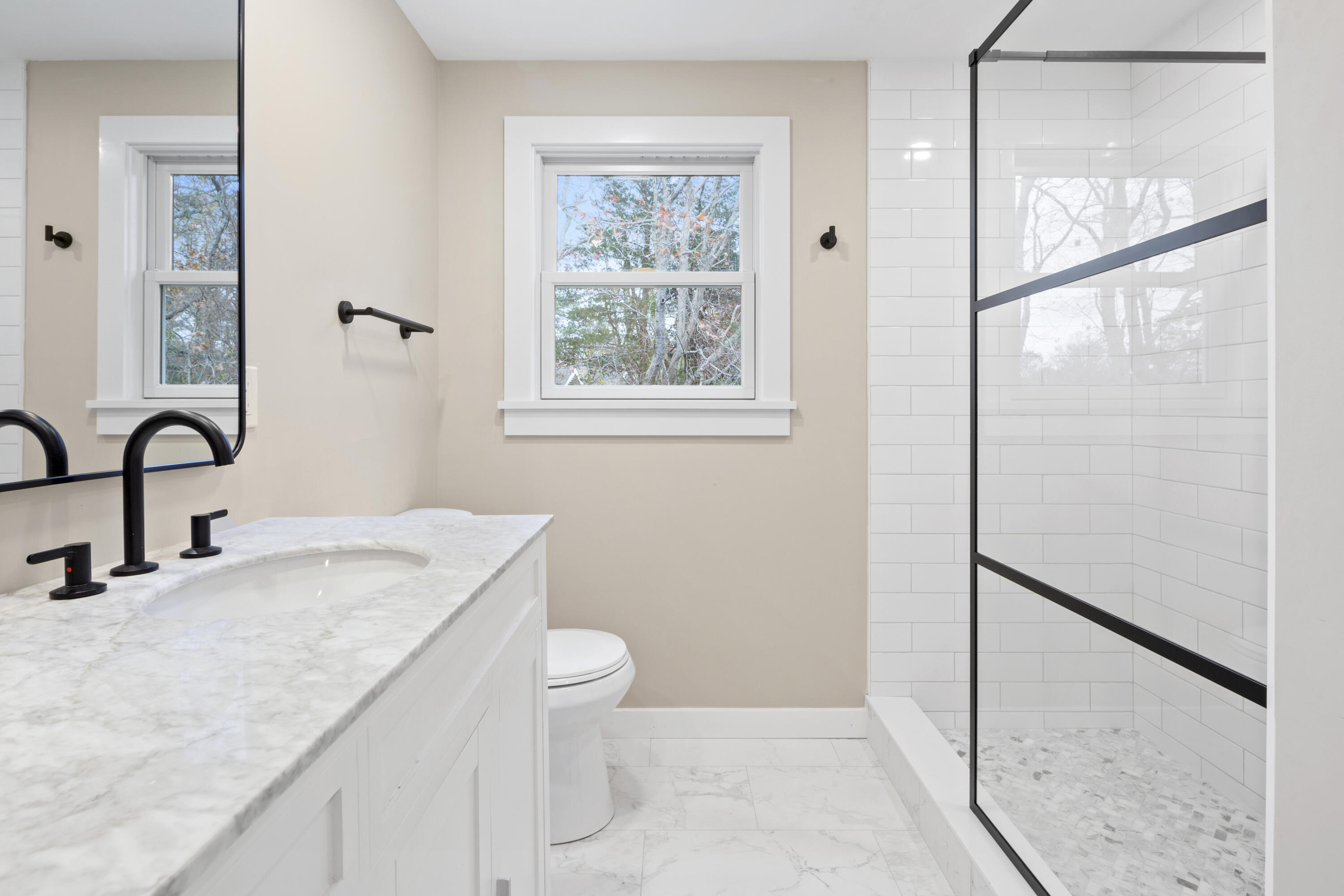 145 Stony Brook Road Brewster, MA 02631 - Photo 26 of 42 a bathroom with a granite countertop sink a toilet and a window