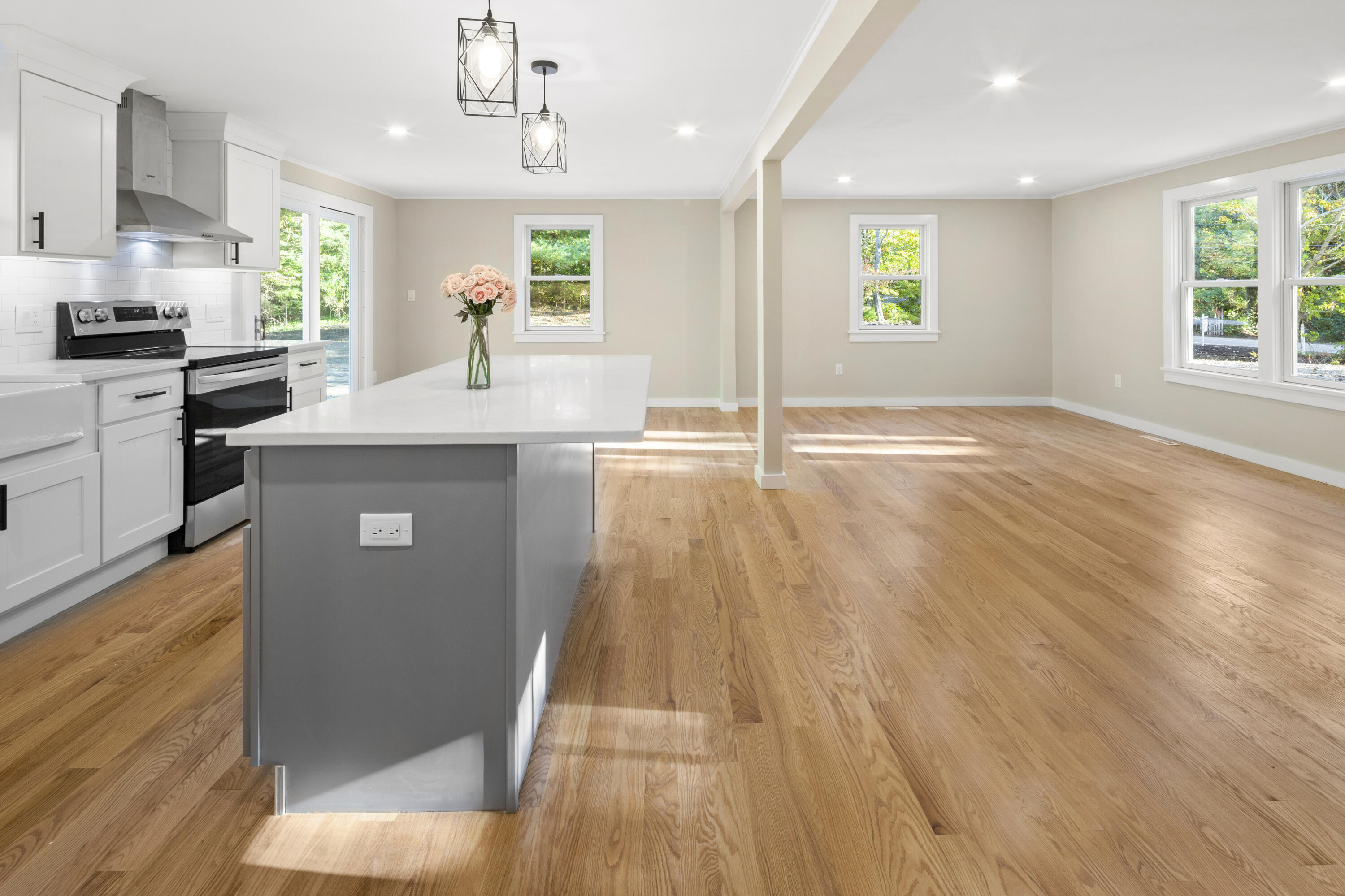 145 Stony Brook Road Brewster, MA 02631 - Photo 10 of 42 a kitchen with kitchen island granite countertop wooden floors and wide window