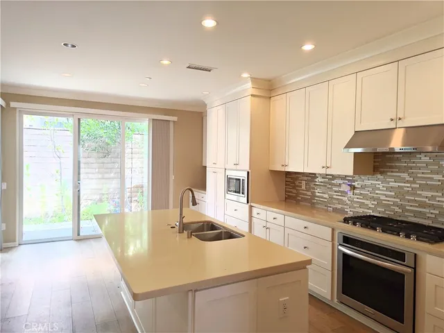 a kitchen that has a sink a stove and wooden floor