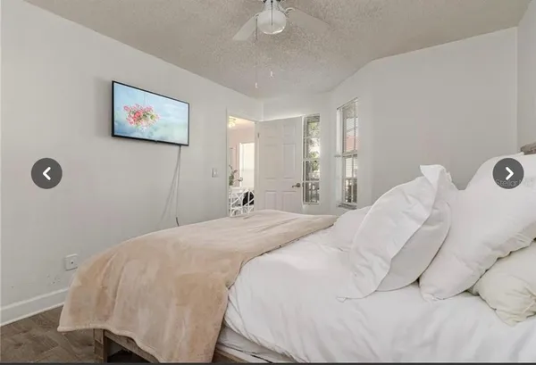 a spacious bedroom with a bed and painting on the wall