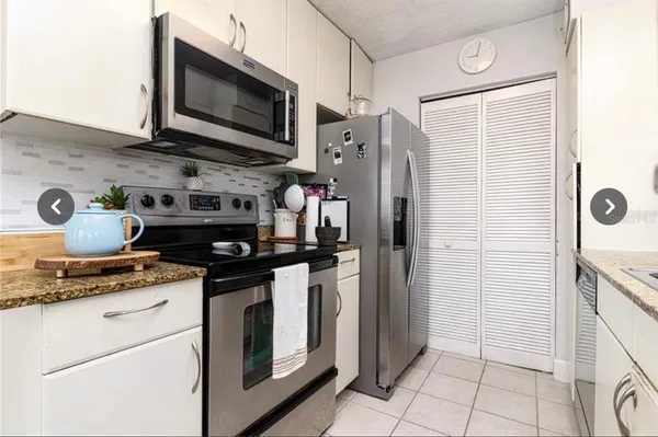 a kitchen with stainless steel appliances granite countertop a stove a refrigerator and a microwave