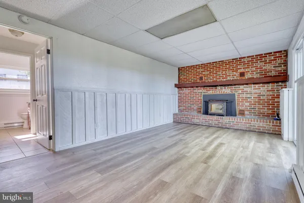 a view of empty room with wooden floor and fireplace