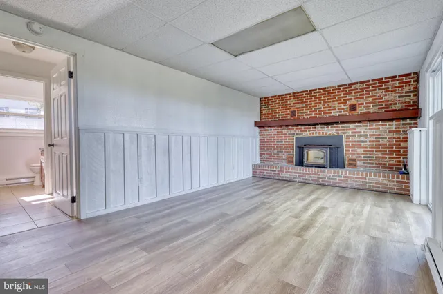 a view of empty room with wooden floor and fireplace
