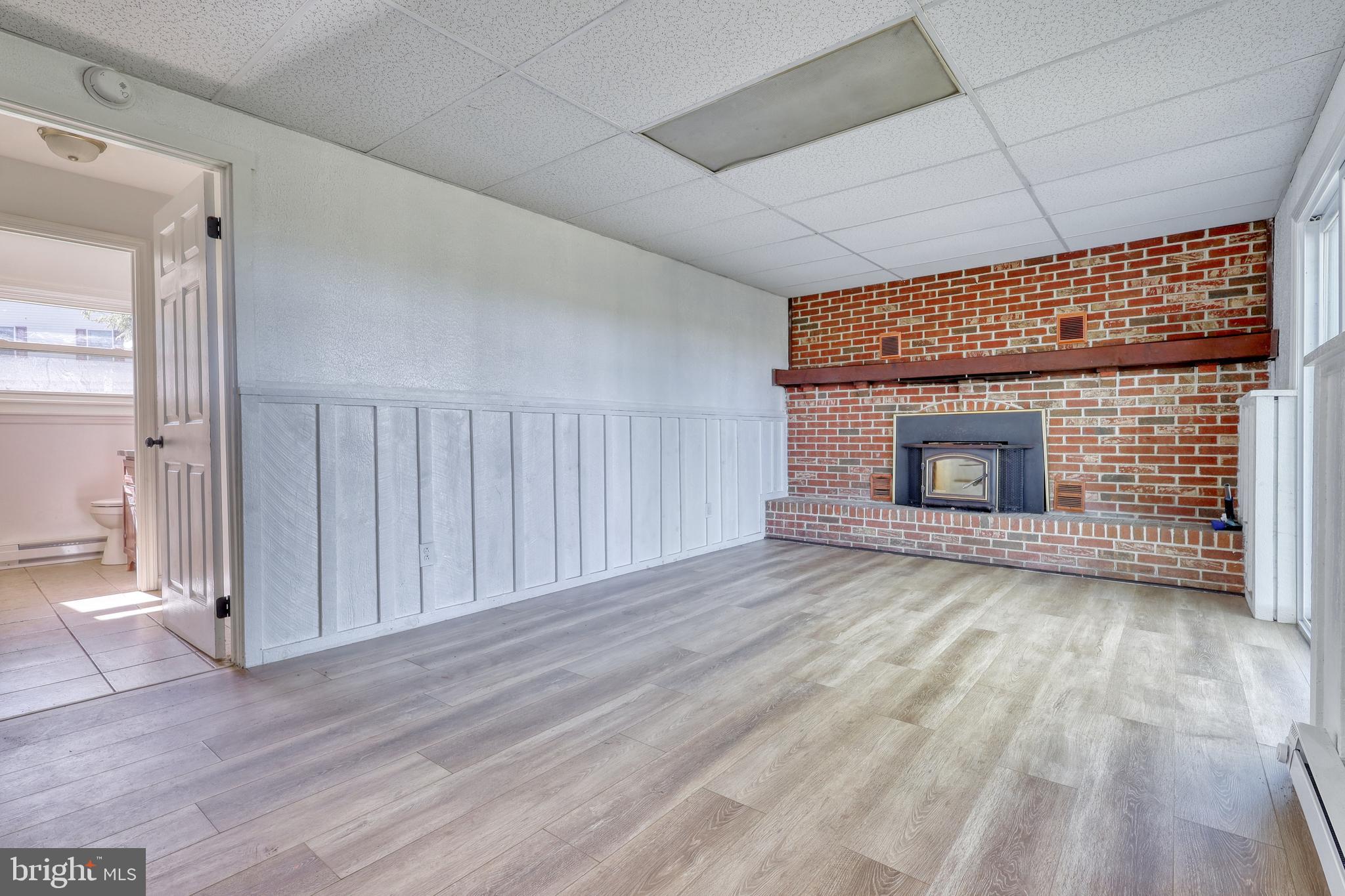 125 Ramblewood Road Pennsylvania Furnace, PA 16865 - Photo 20 of 36 a view of empty room with wooden floor and fireplace
