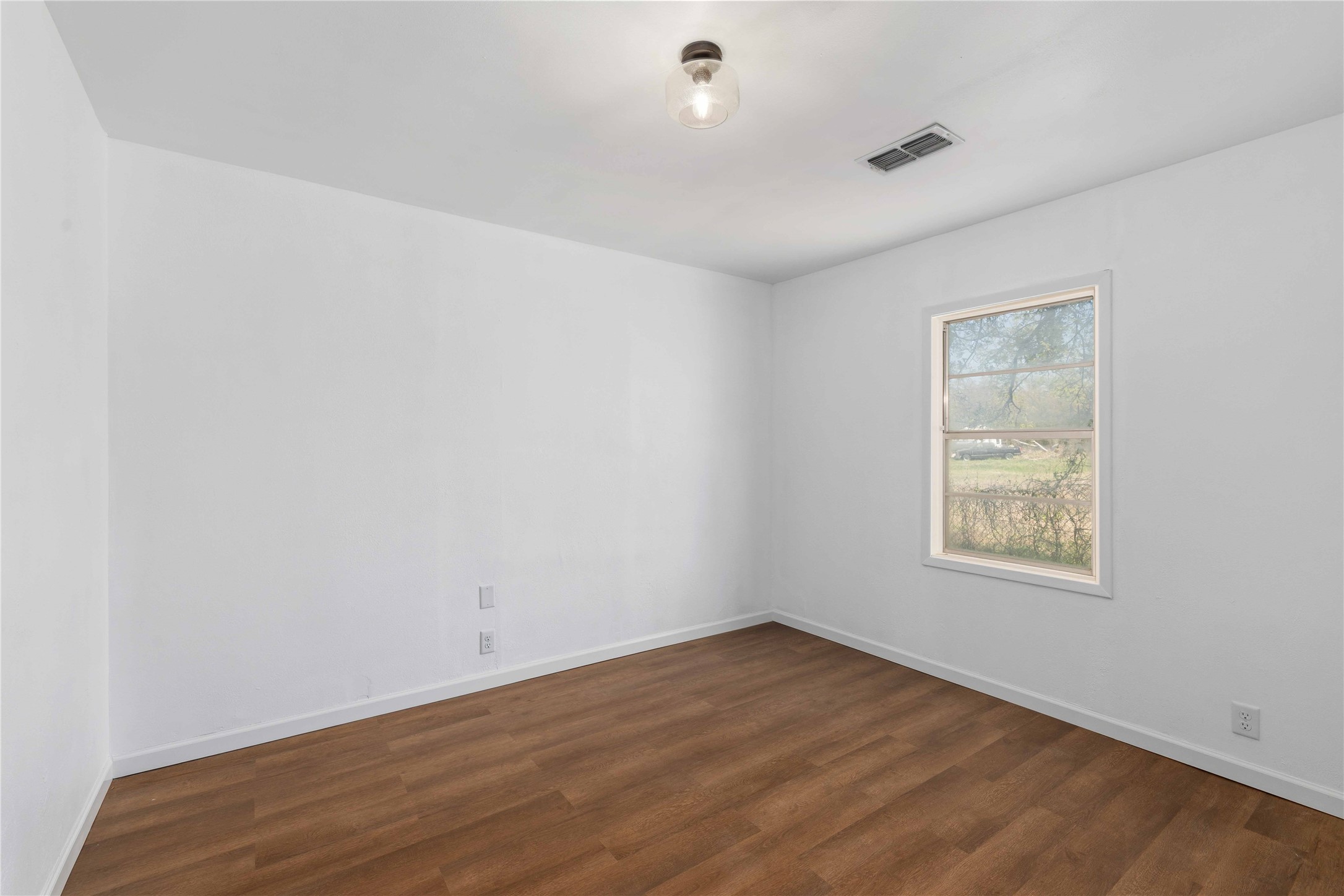 1604 5th Street Goldthwaite, TX 76844 - Photo 16 of 23 an empty room with wooden floor and windows