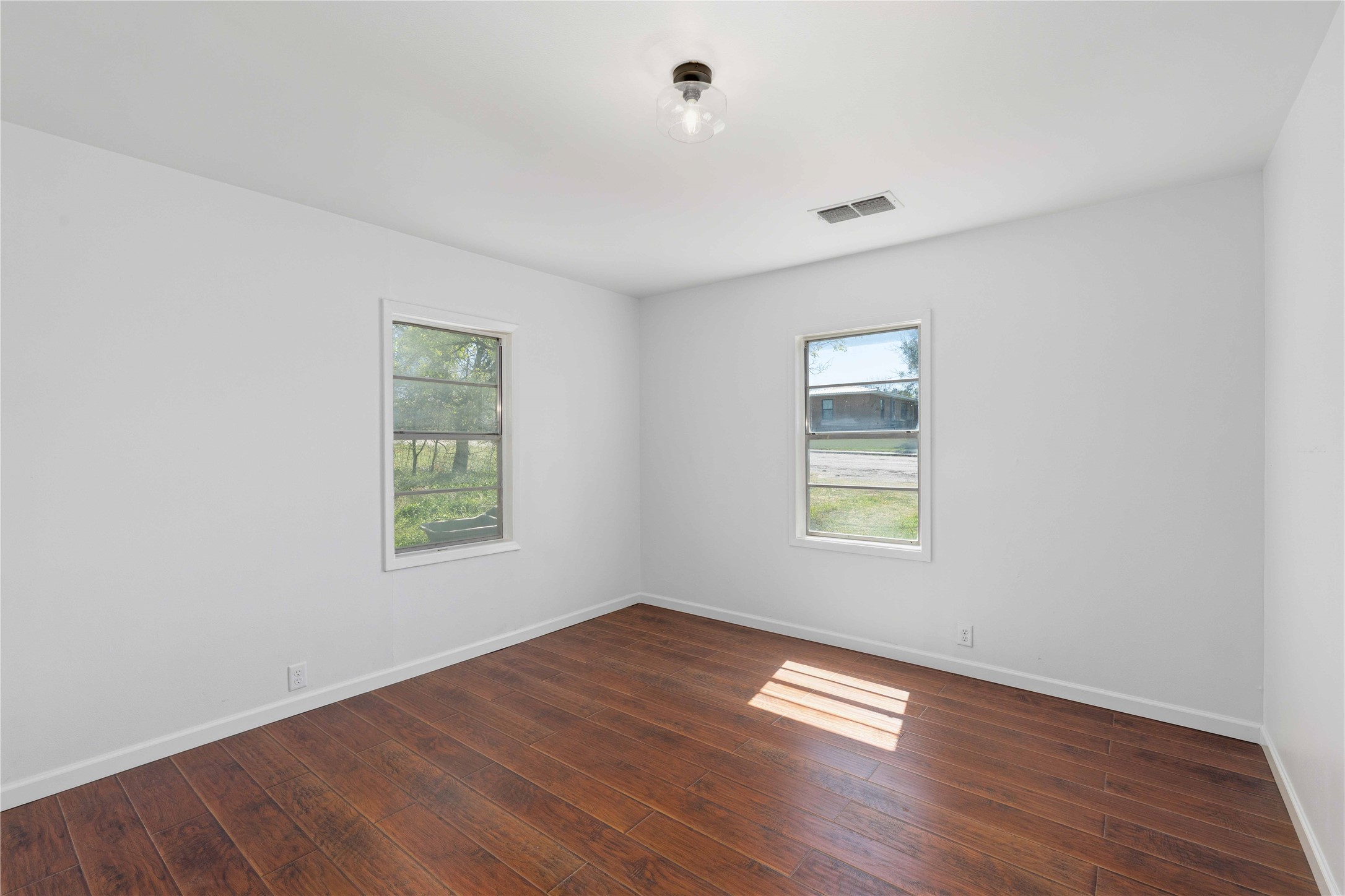 1604 5th Street Goldthwaite, TX 76844 - Photo 17 of 23 an empty room with wooden floor and windows
