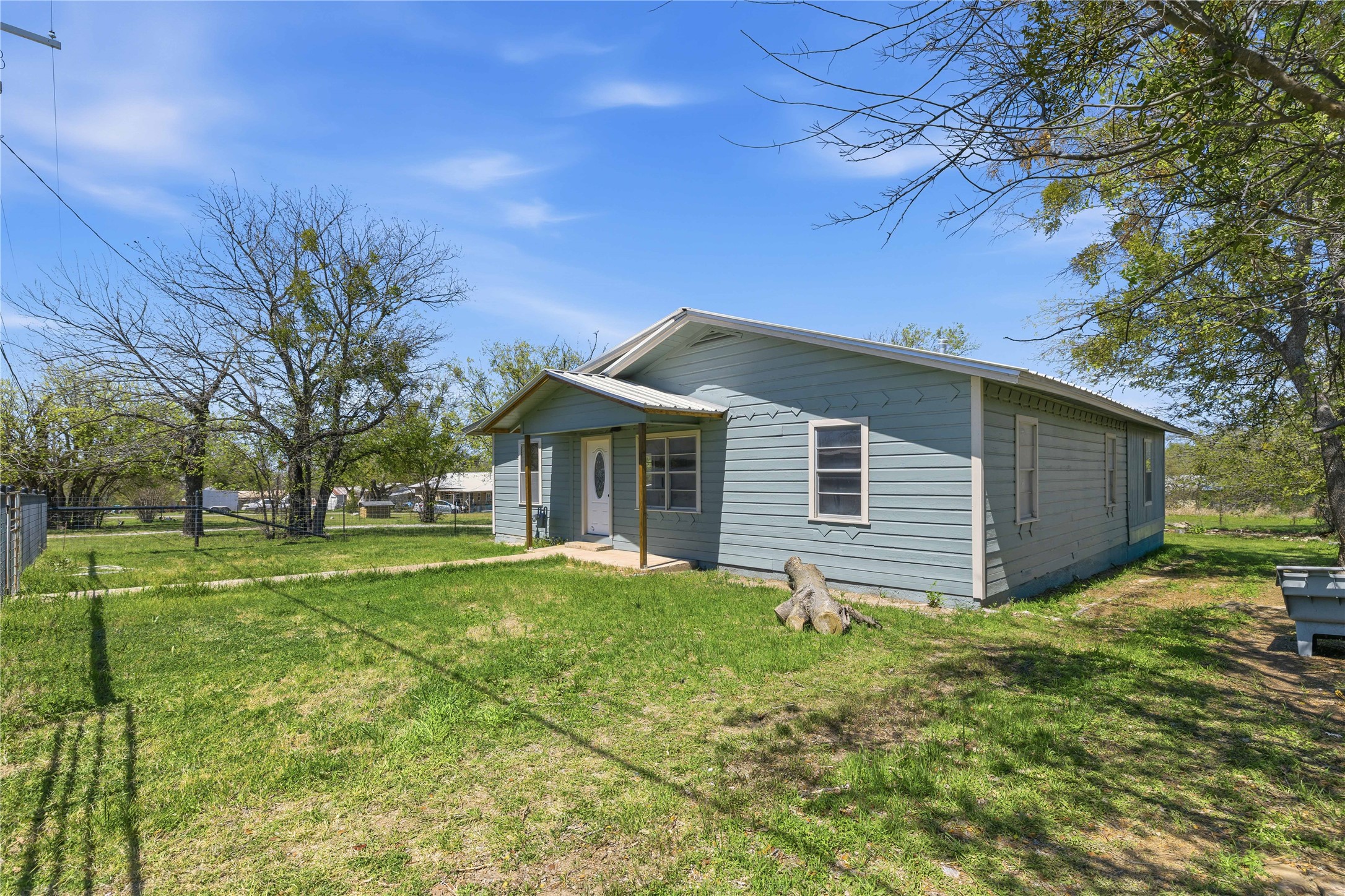 1604 5th Street Goldthwaite, TX 76844 - Photo 2 of 23 a backyard of a house with large trees and plants