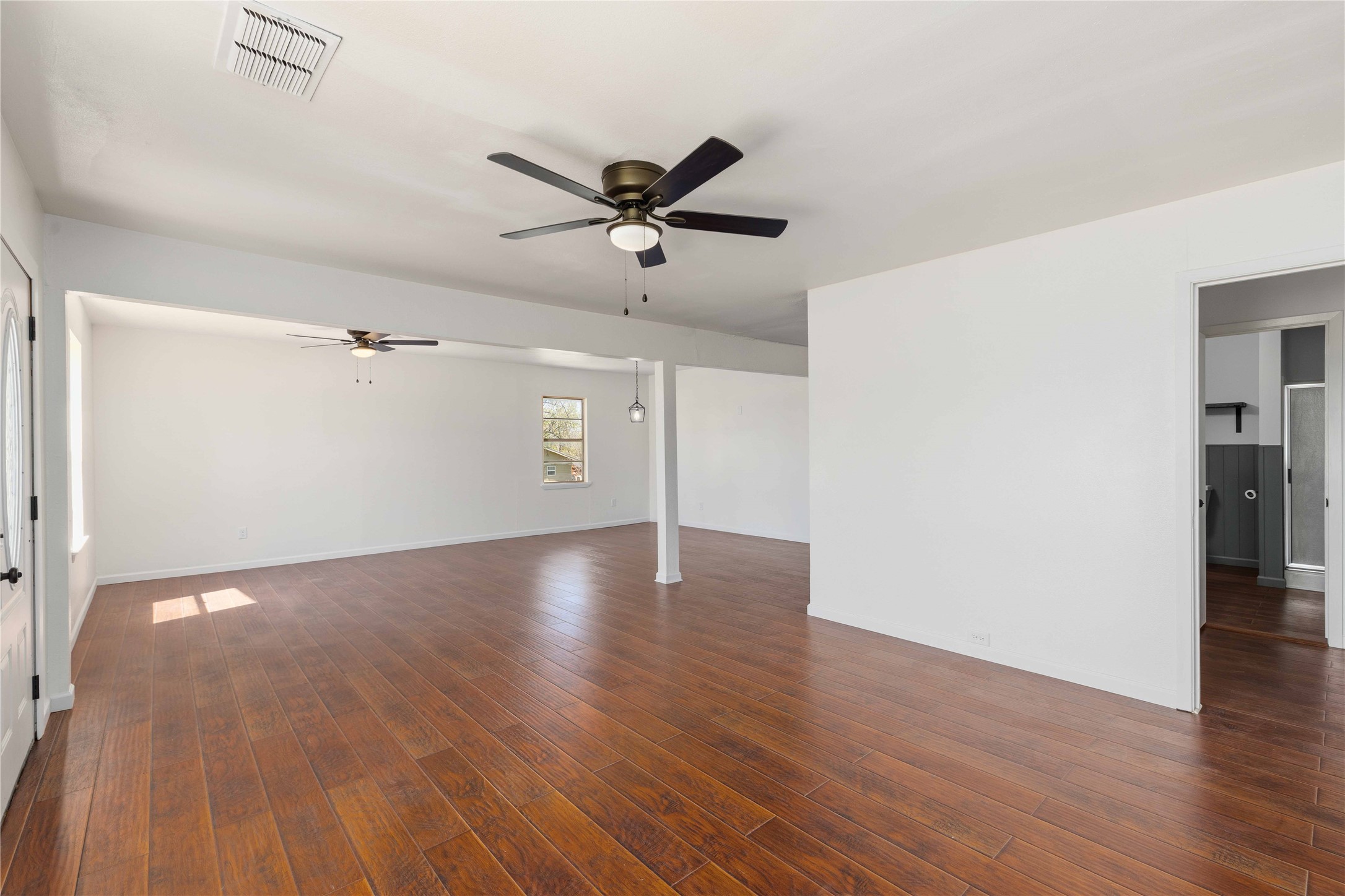 1604 5th Street Goldthwaite, TX 76844 - Photo 8 of 23 a view of a room with wooden floor and a ceiling fan
