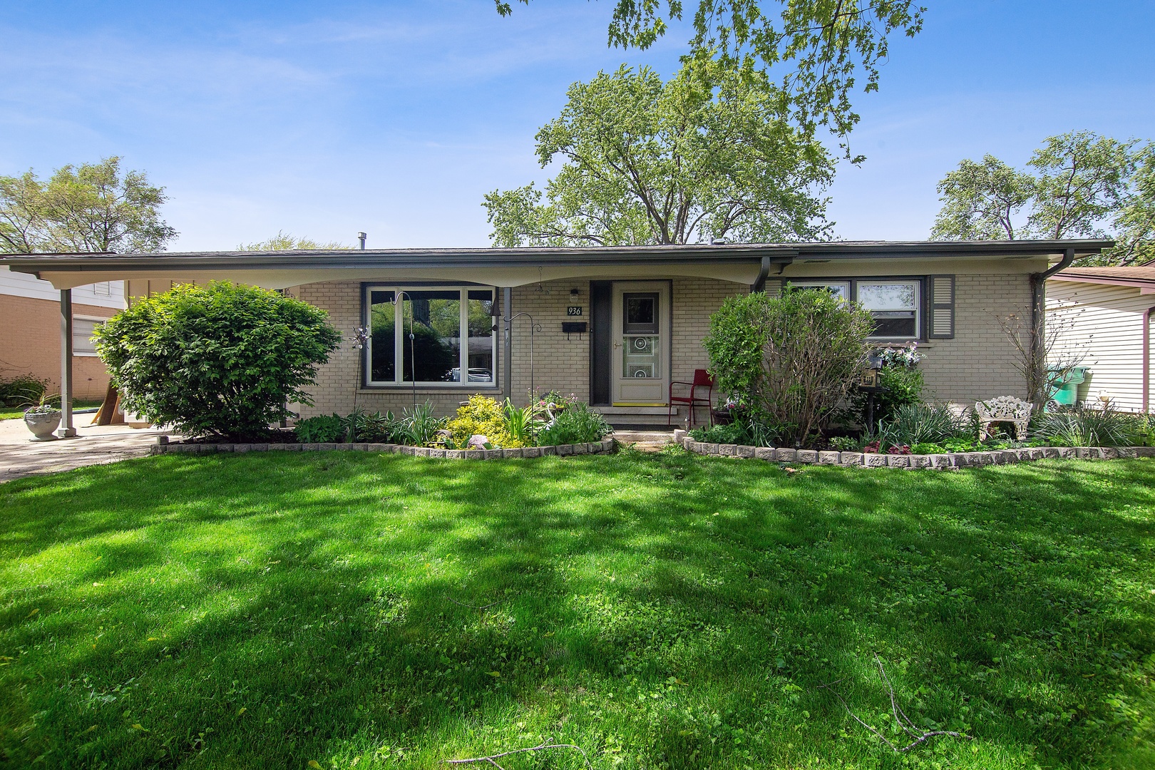 936 Pebble Drive Wheeling, IL 60090 - Photo 1 of 27 a front view of a house with a yard and potted plants