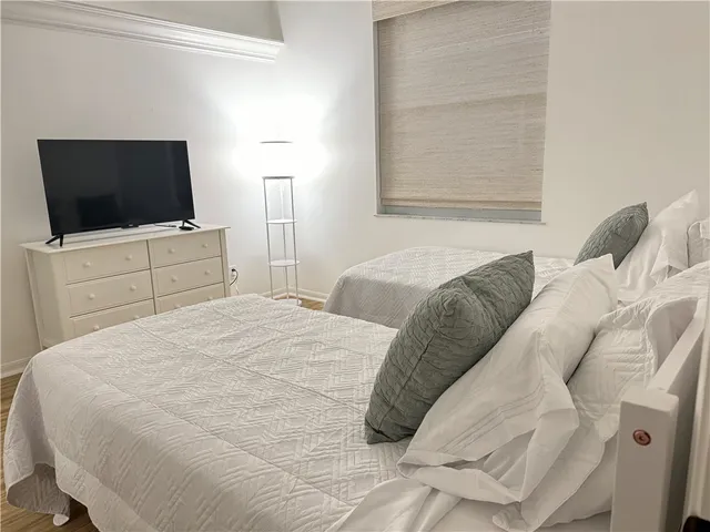 a bedroom with a bed and a flat screen tv