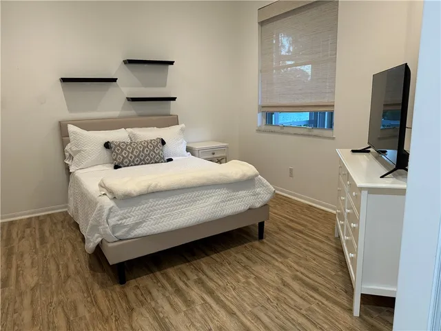 a bedroom with a bed and a flat screen tv