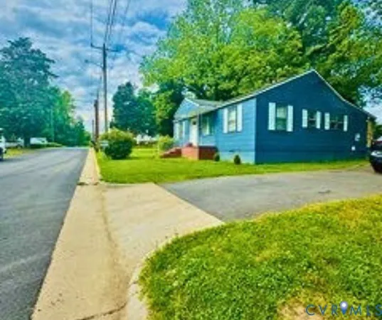 a front view of a house with a yard and trees