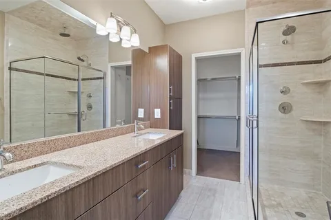 a spacious bathroom with a granite countertop sink mirror and shower
