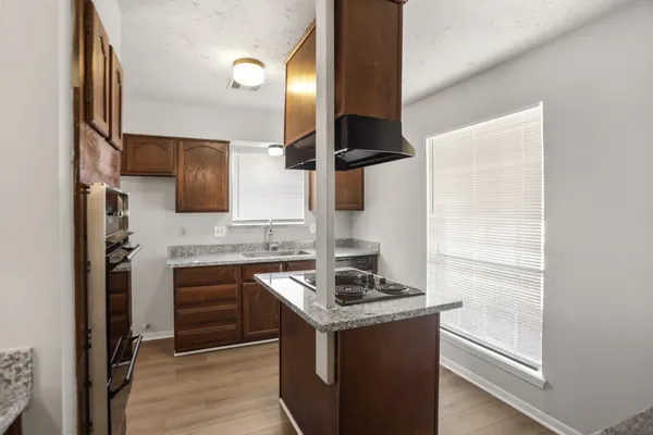 a kitchen with stainless steel appliances granite countertop a sink and a stove