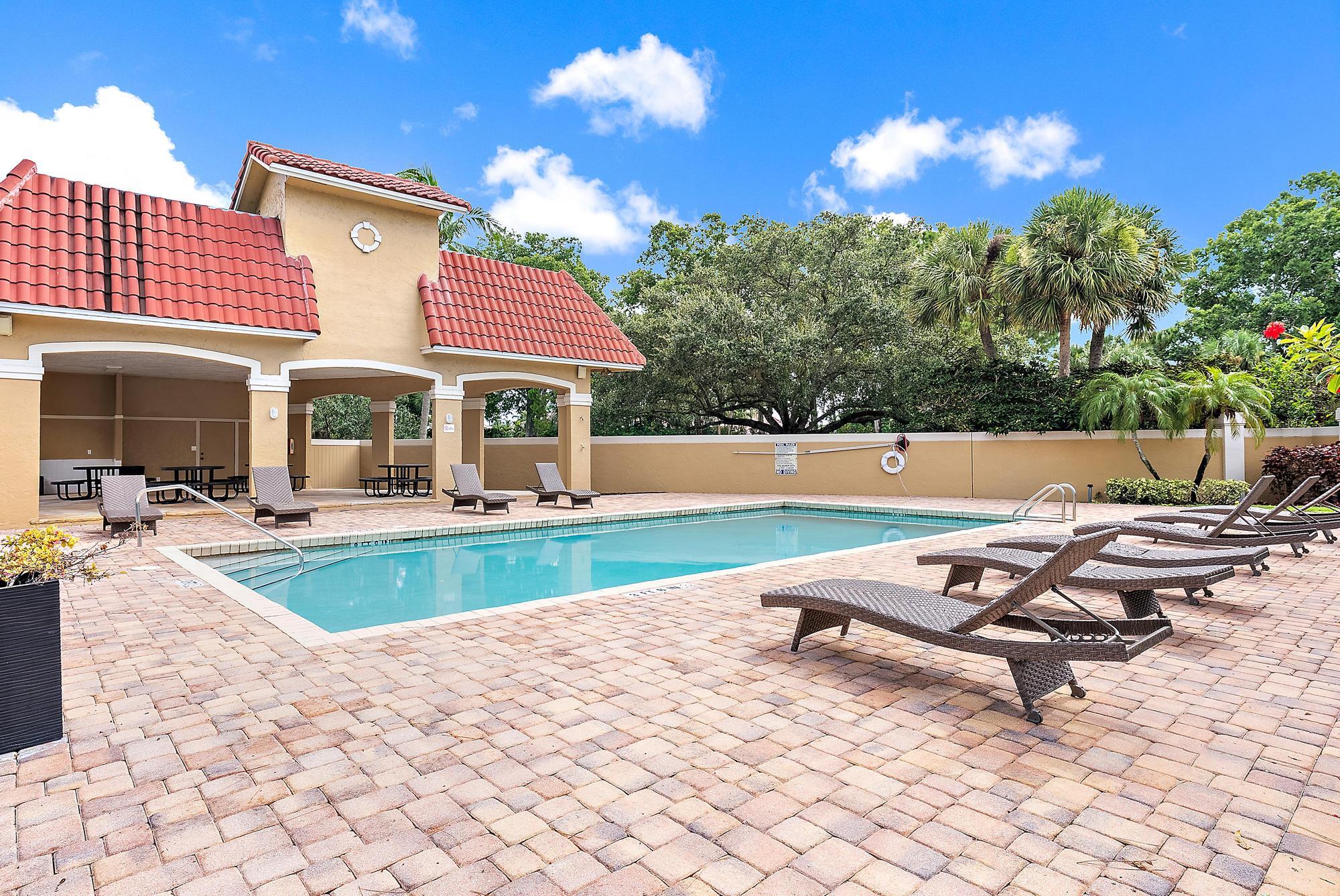 159 St Michaels Court Jupiter, FL 33458 - Photo 19 of 22 a swimming pool with outdoor seating and yard