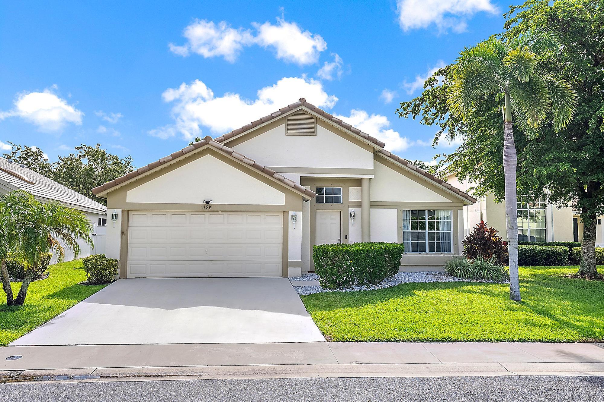 159 St Michaels Court Jupiter, FL 33458 - Photo 22 of 22 a view of a white house next to a yard and trees