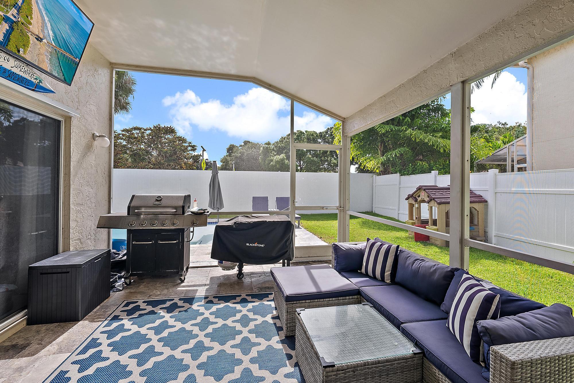 159 St Michaels Court Jupiter, FL 33458 - Photo 4 of 22 a living room with furniture tv and a floor to ceiling window