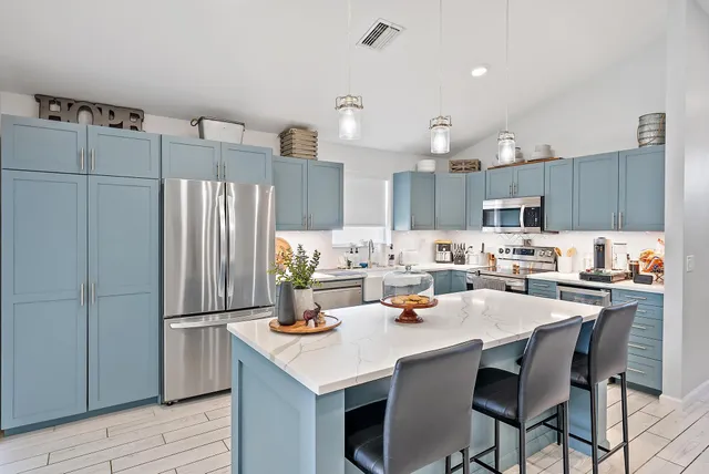 a kitchen with a refrigerator a sink and wooden cabinets