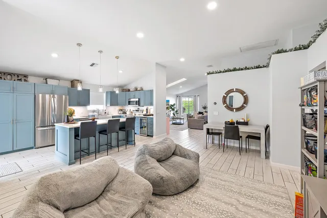 a living room with lots of furniture and kitchen view