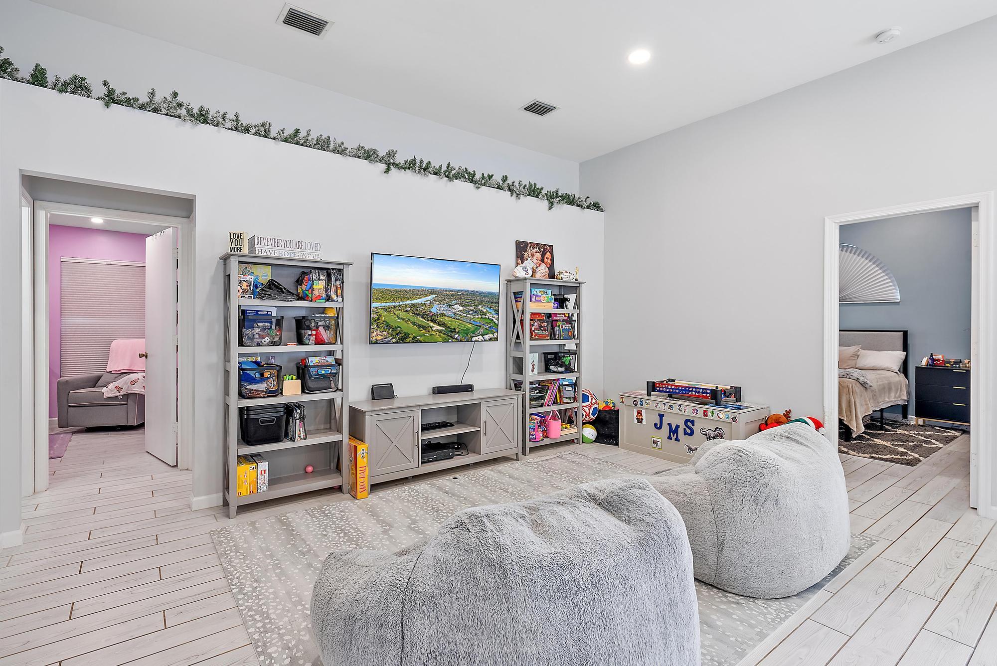 159 St Michaels Court Jupiter, FL 33458 - Photo 8 of 22 a bed room with a bed and a book shelf