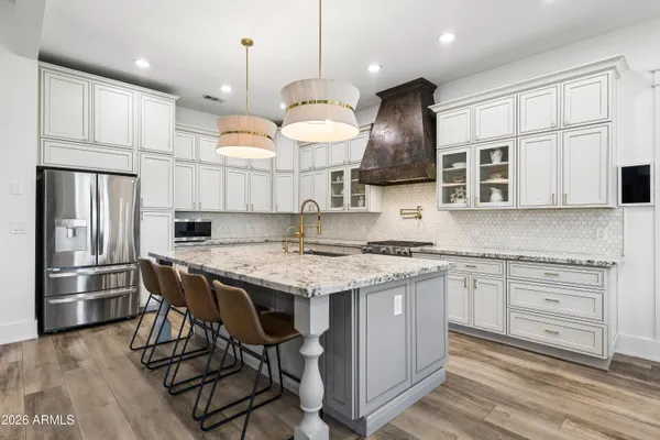a kitchen with stainless steel appliances granite countertop a lot of counter space and wooden floors