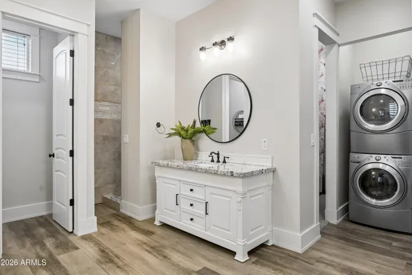 a bathroom with a granite countertop double vanity sink and a mirror