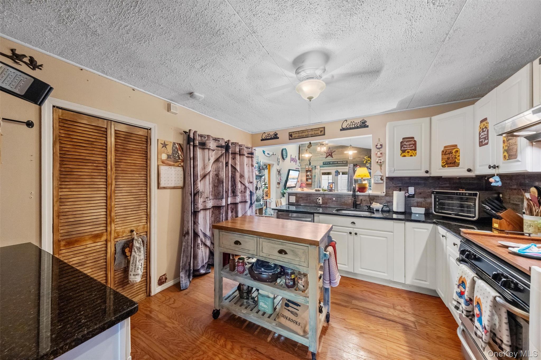 17 Perry Road Cornwall, NY 12518 - Photo 13 of 38 Kitchen featuring white cabinetry, a ceiling fan, light wood-type flooring, range, and a textured ceiling