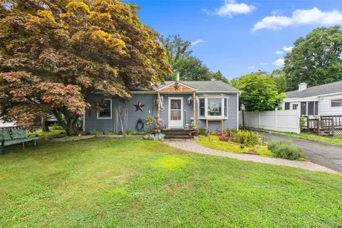 a front view of house with yard and trees