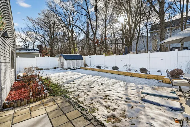 a front view of a house with a yard covered in snow