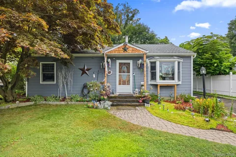 a front view of a house with a yard table and chairs