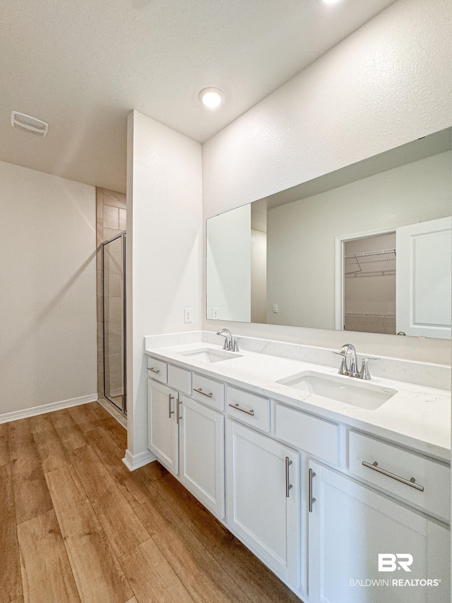 18151 Kent Circle Foley, AL 36535 - Photo 18 of 25 Bathroom featuring a double vanity with white cabinetry, integrated sinks, chrome fixtures, and a full-width mirror