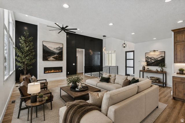 728 East Mountain Road North Ogden, UT 84414 - Photo 4 of 28 Spacious living area featuring a linear fireplace, vaulted ceiling, large windows, recessed lighting, and wood-finish flooring