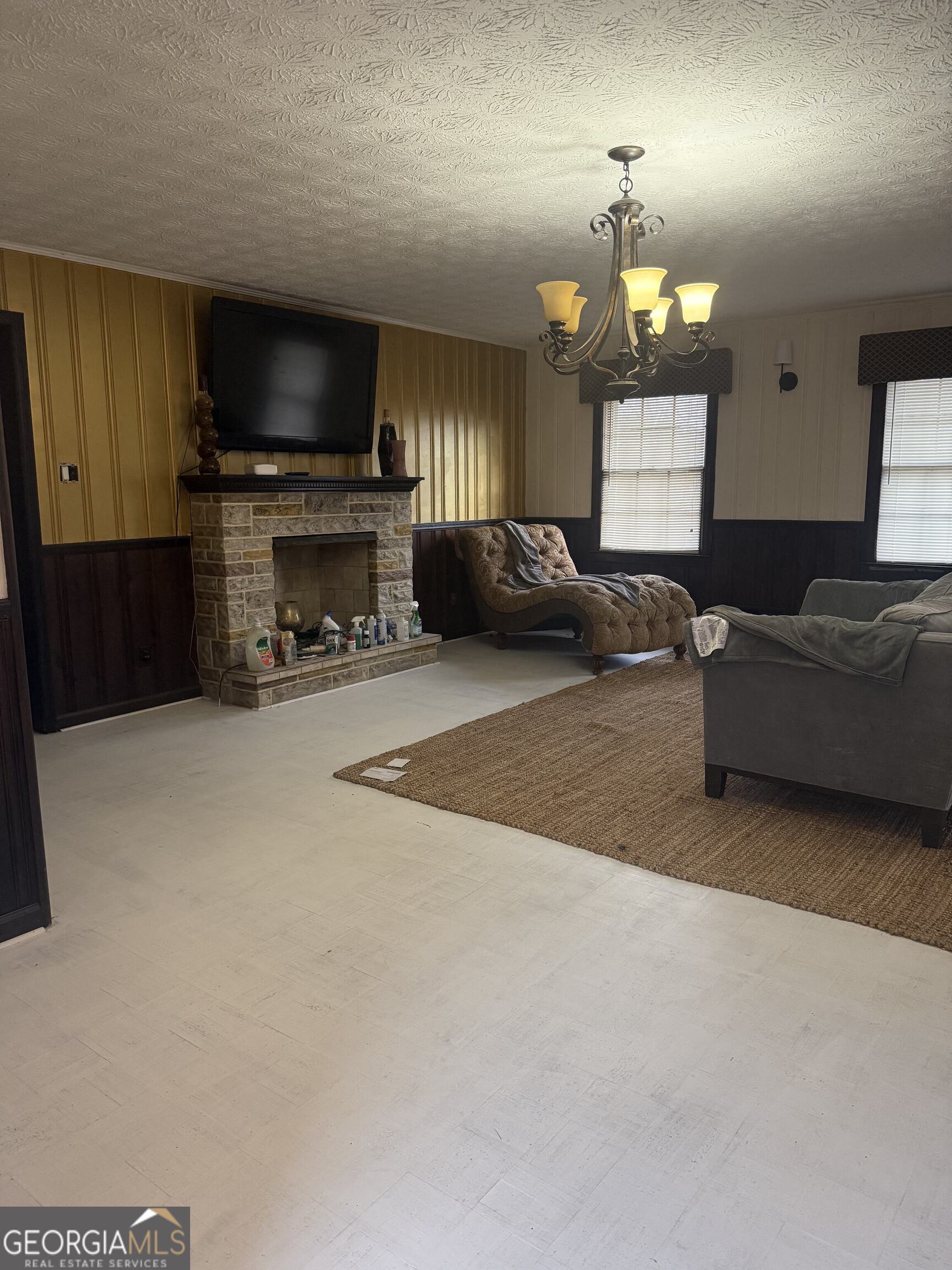3861 Newnan Road Griffin, GA 30223 - Photo 28 of 89 a living room with furniture a fireplace and a flat screen tv