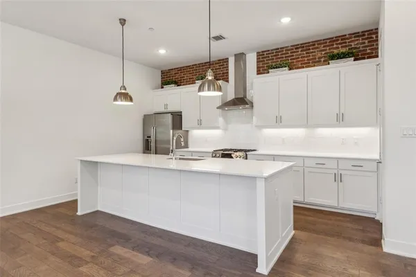 a kitchen with kitchen island a sink stainless steel appliances and cabinets