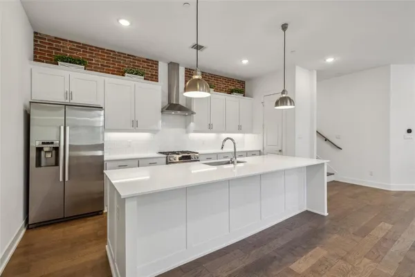 a kitchen with kitchen island a sink stainless steel appliances and a counter top space