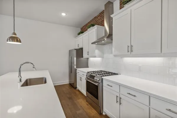 a kitchen with stainless steel appliances granite countertop a sink a stove and a refrigerator