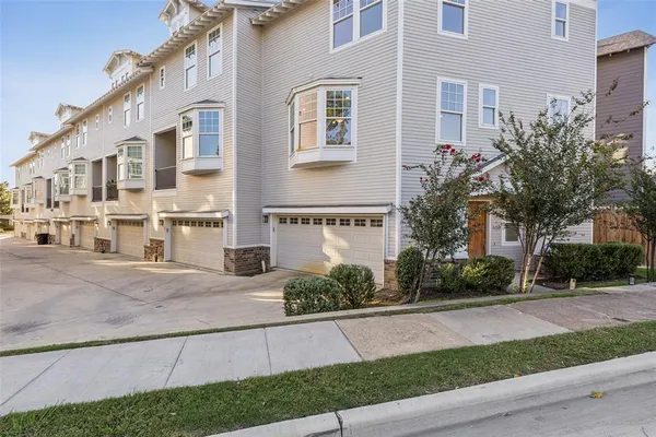 a front view of a building with a garden and plants