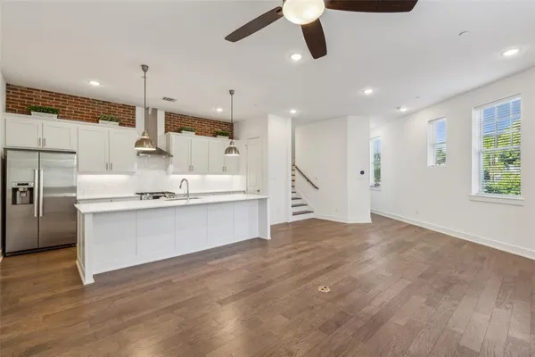 a large white kitchen with a large counter top appliances and cabinets