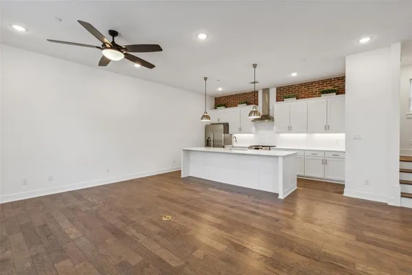 a view of a kitchen with kitchen island a sink stainless steel appliances and cabinets