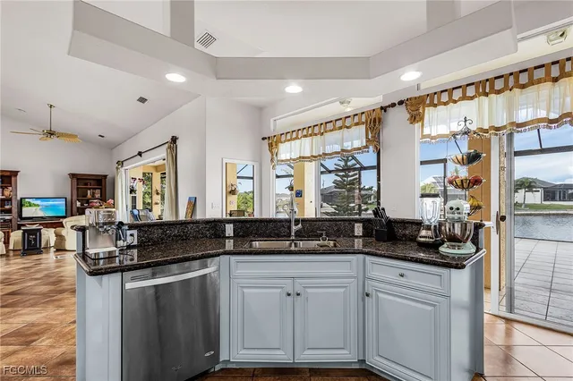 a kitchen with granite countertop a sink and white cabinets