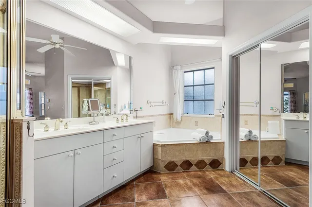a spacious bathroom with a double vanity sink a mirror and a bathtub