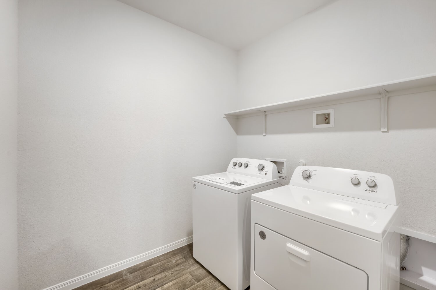 13507 Howser Trace Manor, TX 78653 - Photo 22 of 28 Functional laundry space featuring modern appliances and a convenient storage shelf for household essentials.
