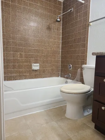 a bathroom with a granite countertop sink a toilet and mirror
