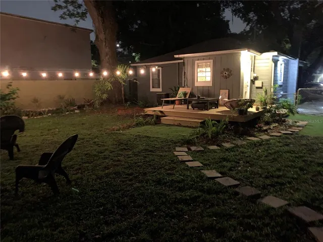 a view of a house with backyard and sitting area