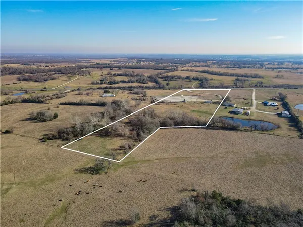 a view of a field with trees in the background