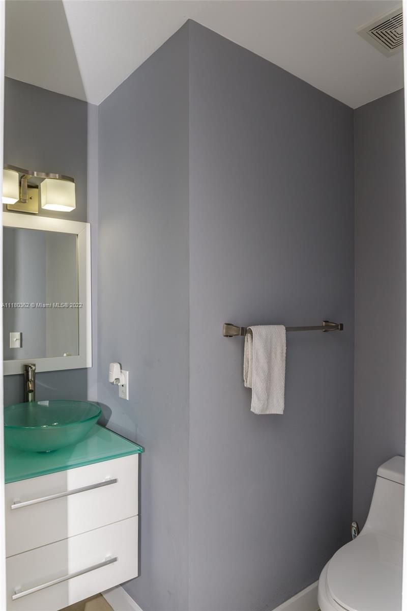 6301 Collins Avenue, Unit PH4 Miami Beach, FL 33141 - Photo 11 of 18 a bathroom with a sink toilet and mirror