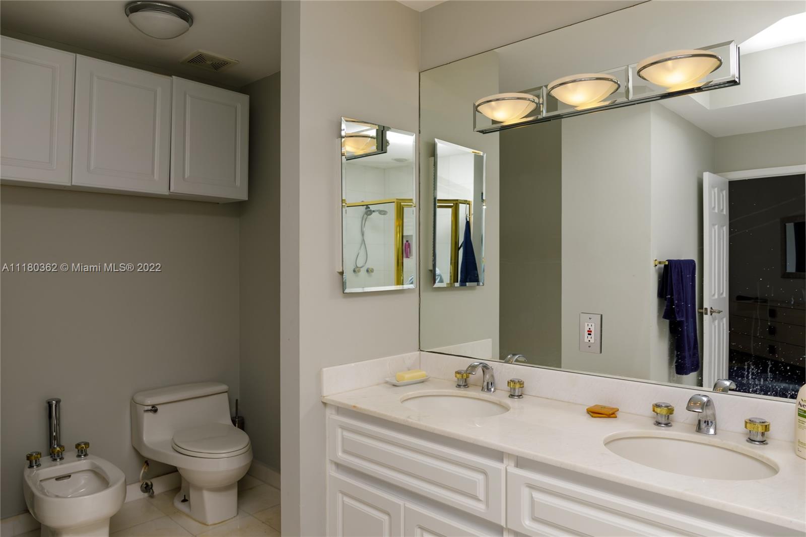 6301 Collins Avenue, Unit PH4 Miami Beach, FL 33141 - Photo 15 of 18 a bathroom with a toilet sink and mirror