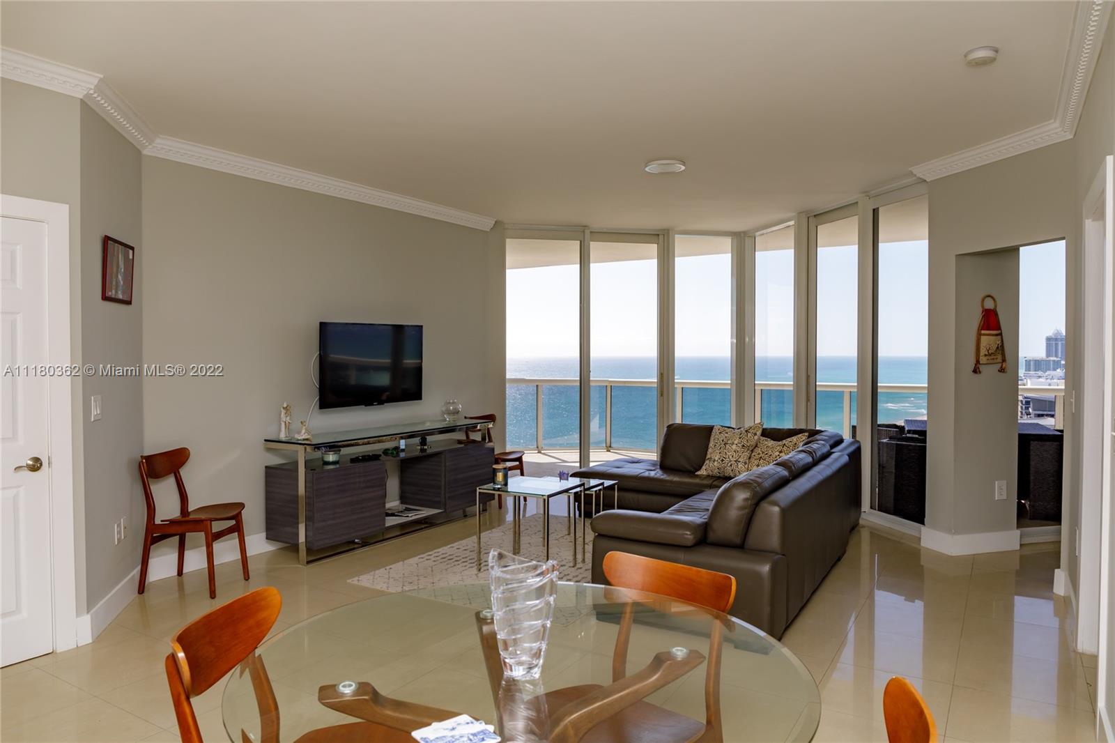 6301 Collins Avenue, Unit PH4 Miami Beach, FL 33141 - Photo 3 of 18 a living room with furniture a flat screen tv and a large window