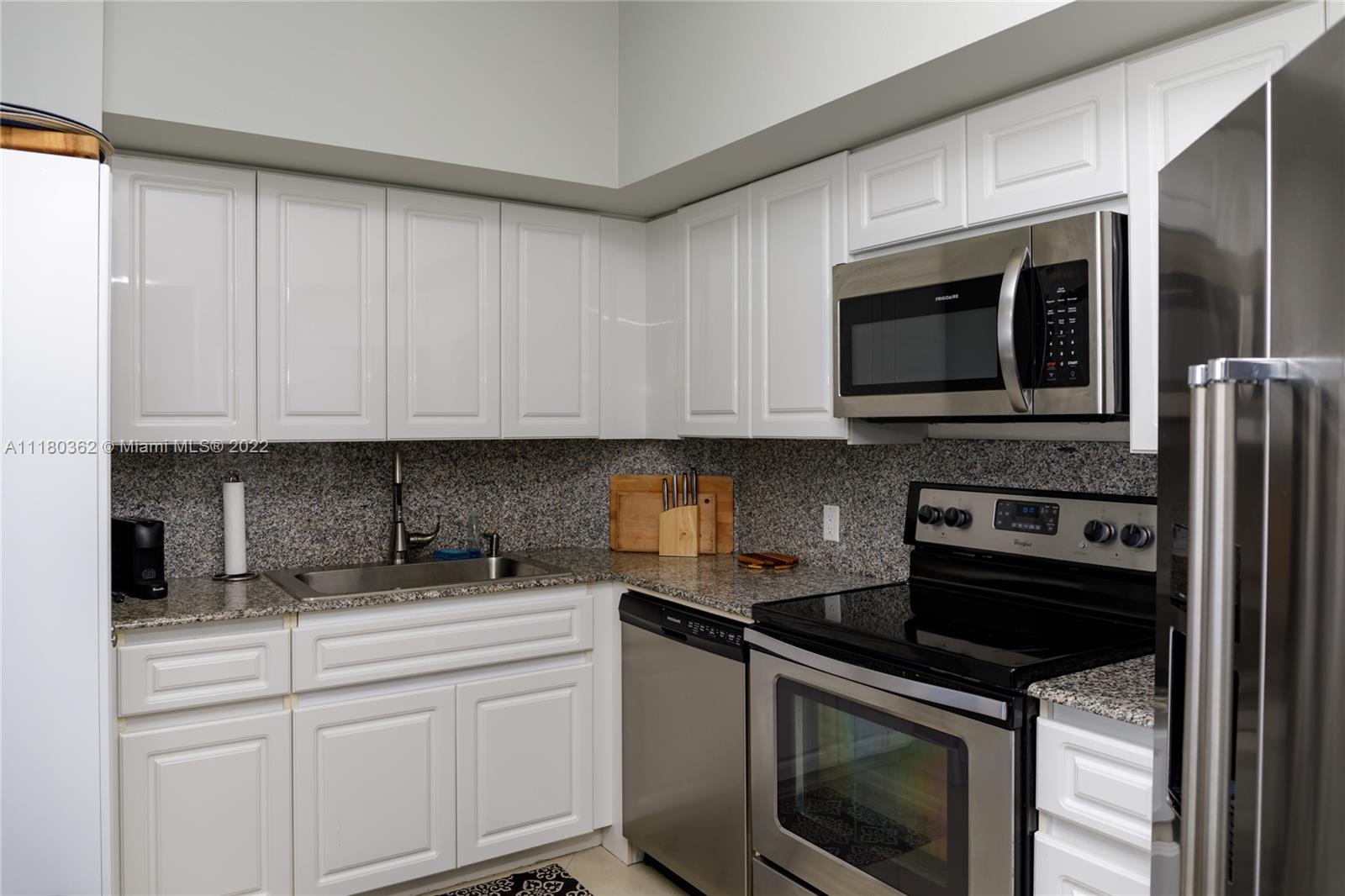 6301 Collins Avenue, Unit PH4 Miami Beach, FL 33141 - Photo 10 of 18 a kitchen with stainless steel appliances granite countertop a stove microwave and sink
