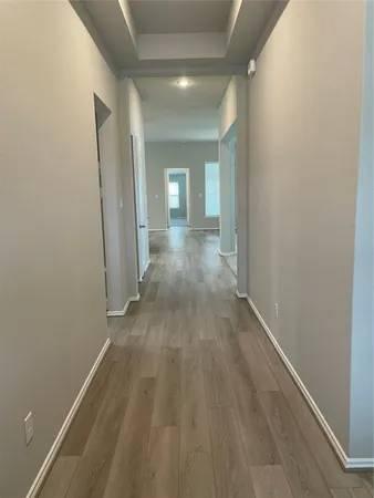 a view of a hallway with wooden floor